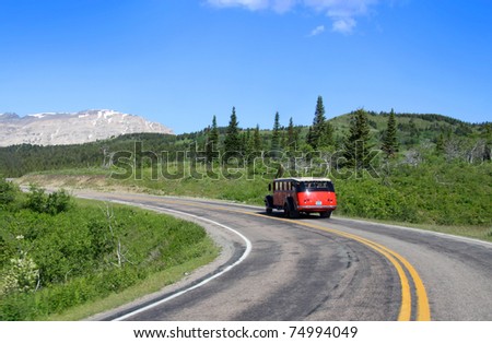 Red tour bus on road in scenic Glacier national park