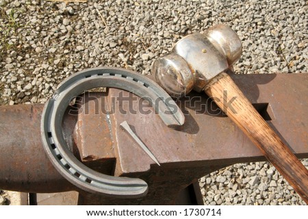 Lying on the anvil the hammer, horseshoe and nail wait for the farrier to shoe the horse
