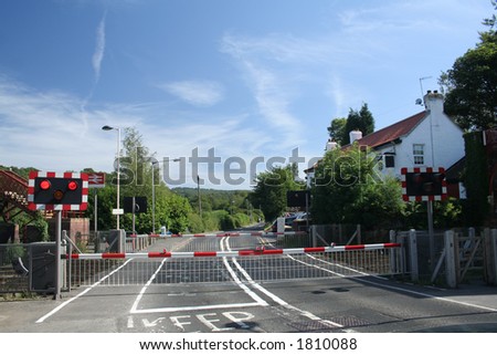 Red lights flash to tell the motorists that a train is coming and the red and white barriers go down to stop cars from crossing the tracks