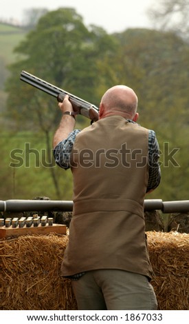 Man takes aims and fires at the clay pigeon