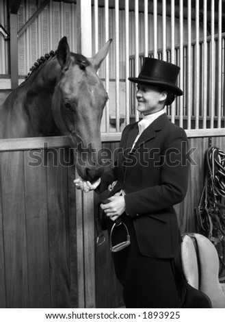 Elegant lady pats her horse before riding side saddle
