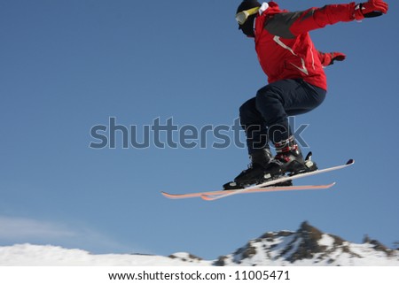 Skier jumps into the air with mountains behind