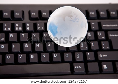 glass globe close up on computer keyboard, shallow
