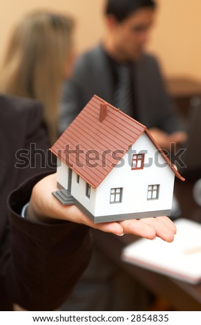 businesswoman holding mini house for real estate concept