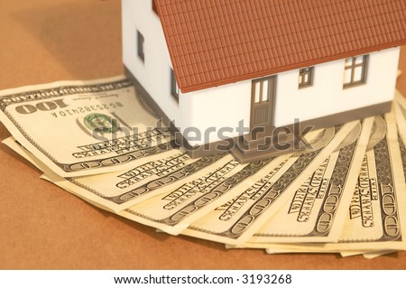 mini house with US dollars on old paper, shallow dof