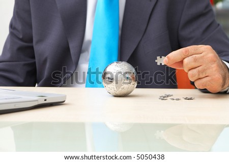 business concept with puzzle globe and businessman at the office