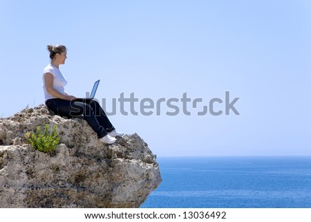 beautiful woman with her laptop on the top of the mountain