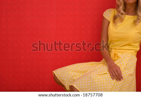 fashion portrait on red wall background with yellow dress