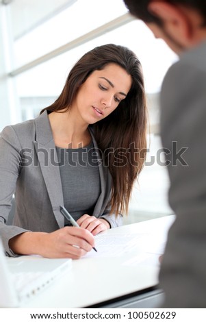 Businesswoman writing on document after meeting