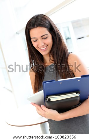Young businesswoman in modern building holding files