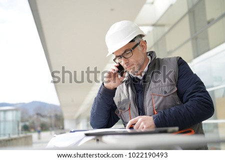 Engineer working on outdoor project and talking on phone
