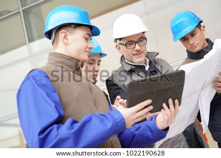 Construction manager giving instructions to training students