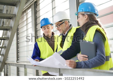 Construction site manager with young people in training period