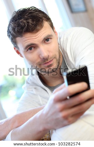 Young man using mobile phone to send short message