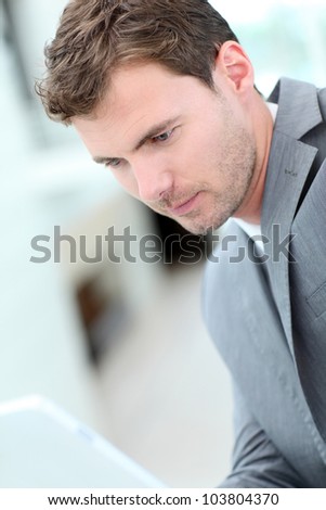 Portrait of businessman using electronic tablet in hall