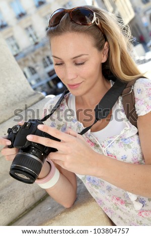 Portrait of young tourist looking at camera screen
