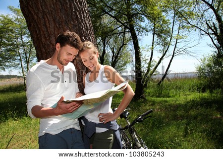 Couple on a bike ride making a stop to look at map