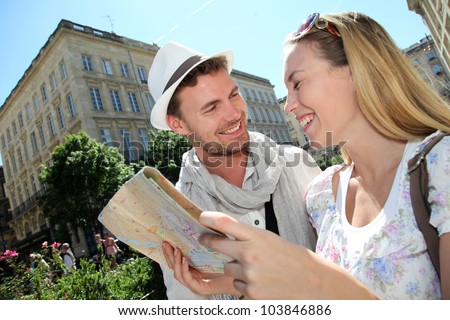 Couple of tourists looking at city tour map