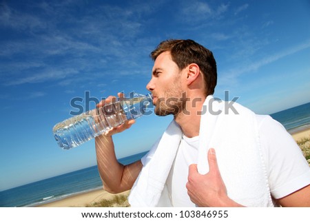 Portrait of jogger drinking water from bottle