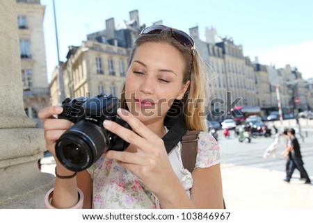 Portrait of young tourist looking at camera screen