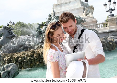 Couple standing by the fountain on the Quinconces Square in Bordeaux, France