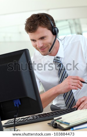 Customer service representative sitting in front of desktop