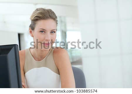 Beautiful blond office-worker sitting at her desk