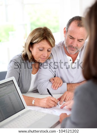 Senior couple signing financial contract