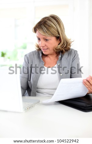 Senior woman using internet to get some help with paper work