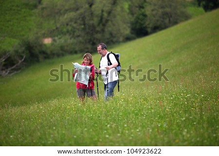 Senior hikers reading map in country field