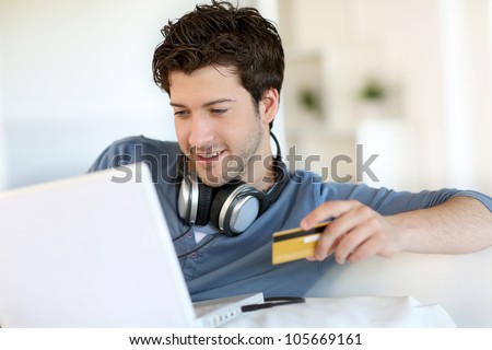 Young man buying music on internet with tablet