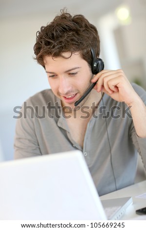 Student at home working with laptop and headset