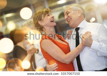 Romantic senior couple dancing together at dance hall