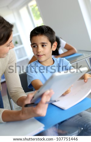 Teacher and schoolboy using electronic tablet in class Teacher and schoolboy using electronic tablet in class