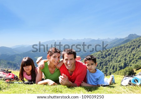 Portrait of happy family laying on the grass in mountain
