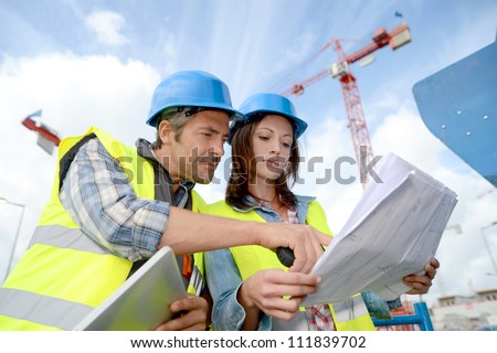 Construction manager and engineer working on building site