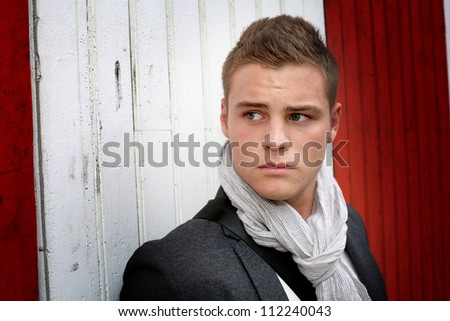 Portrait of young man standing on garage door