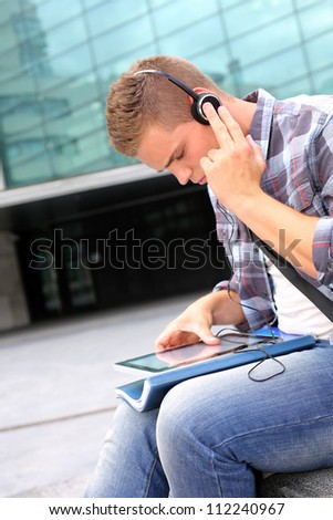 University student using digital tablet and headphones