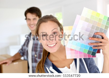 Smiling girl holding colour charts to decorate house