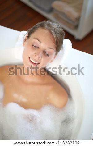 Woman with eyes shut in bathtub