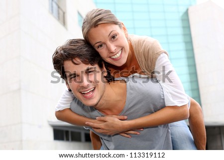 Man giving piggyback ride to girlfriend