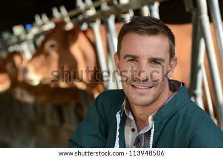 Portrait of smiling farmer with cows in background