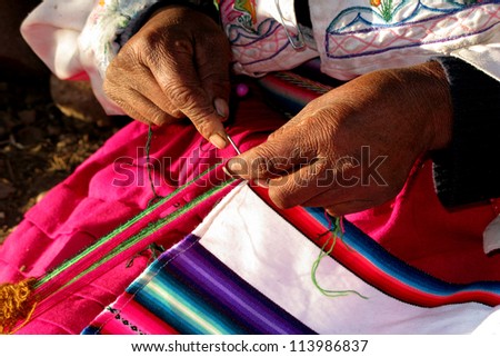 Closeup of elderly woman\'s hands spinning wool, Peru