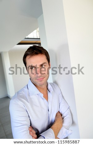 Man leaning on wall with arms crossed