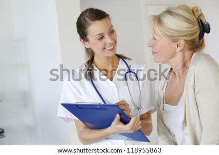 Nurse Giving Presciption To Elderly Woman
