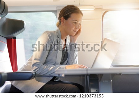 Businesswoman working on  laptop on a train