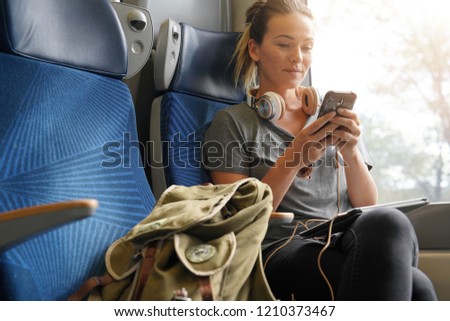 Relaxed woman texting on train