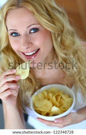 Smiling woman eating potato chips