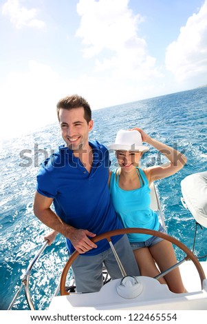 Young couple navigating on a yacht in caribbean sea Young couple navigating on a yacht in caribbean sea