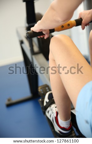 Woman using rowing equipment in gym center